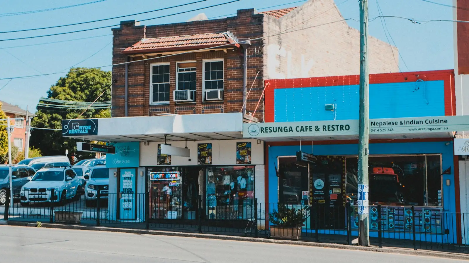 Row of Australian shopfronts and a café on a sunny high street