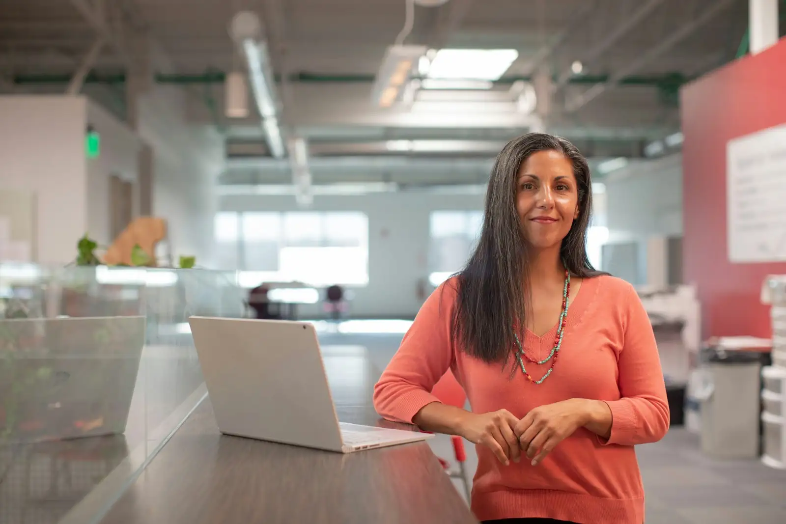 Business owner standing at her desk with a laptop